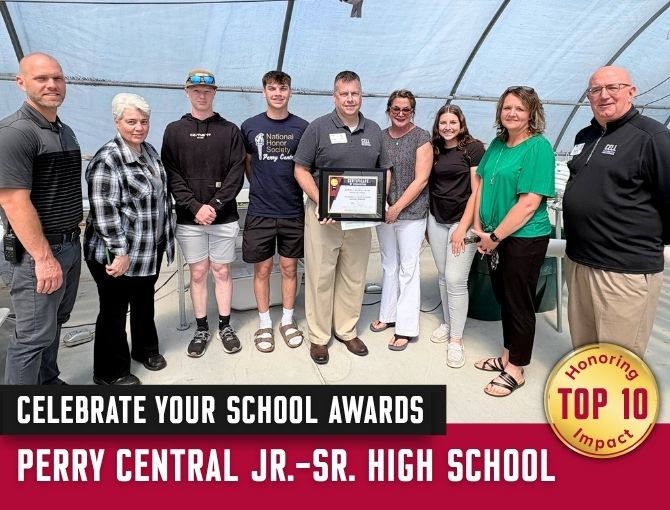 Students, teachers, and CELL staff pose in a greenhouse with an award for Perry Central Jr-Sr High