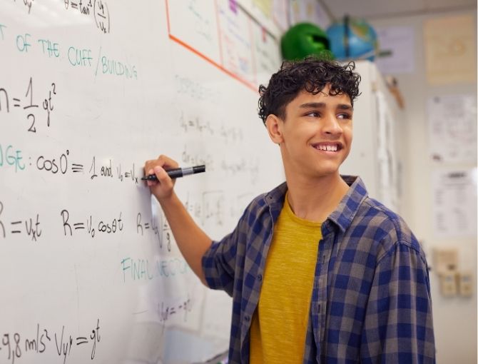 Student writing on whiteboard