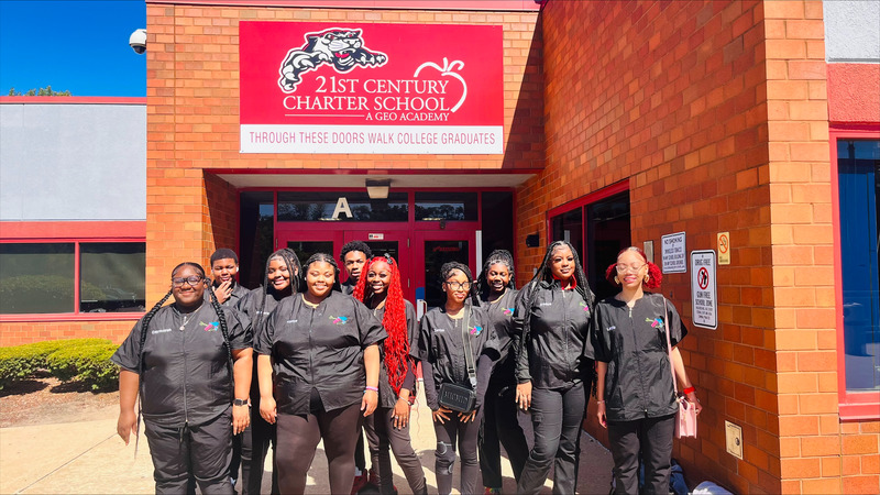 Students in graduation caps and gowns outside 21st Century Charter School