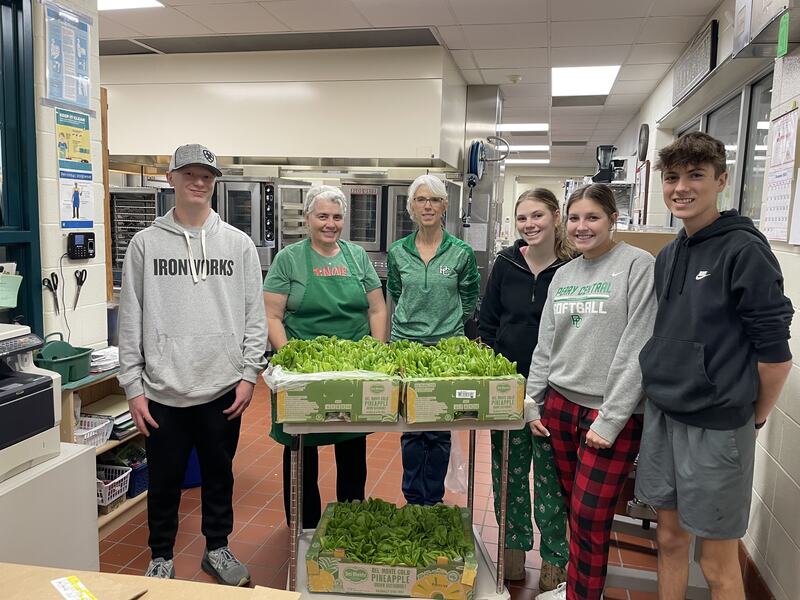 Students and cafeteria staff with lettuce delivery