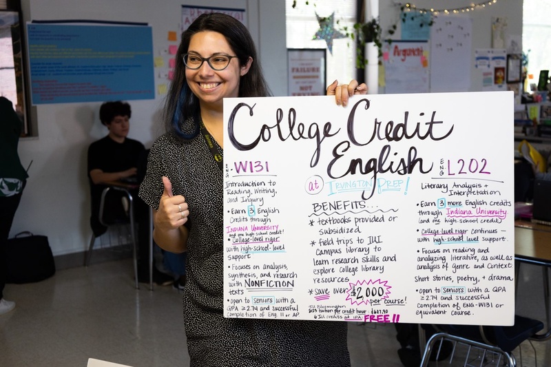 Person holding College Credit English sign with courses and benefits