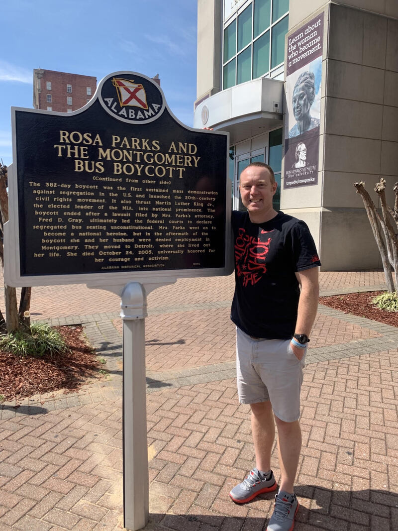 Person standing next to Rosa Parks historical marker